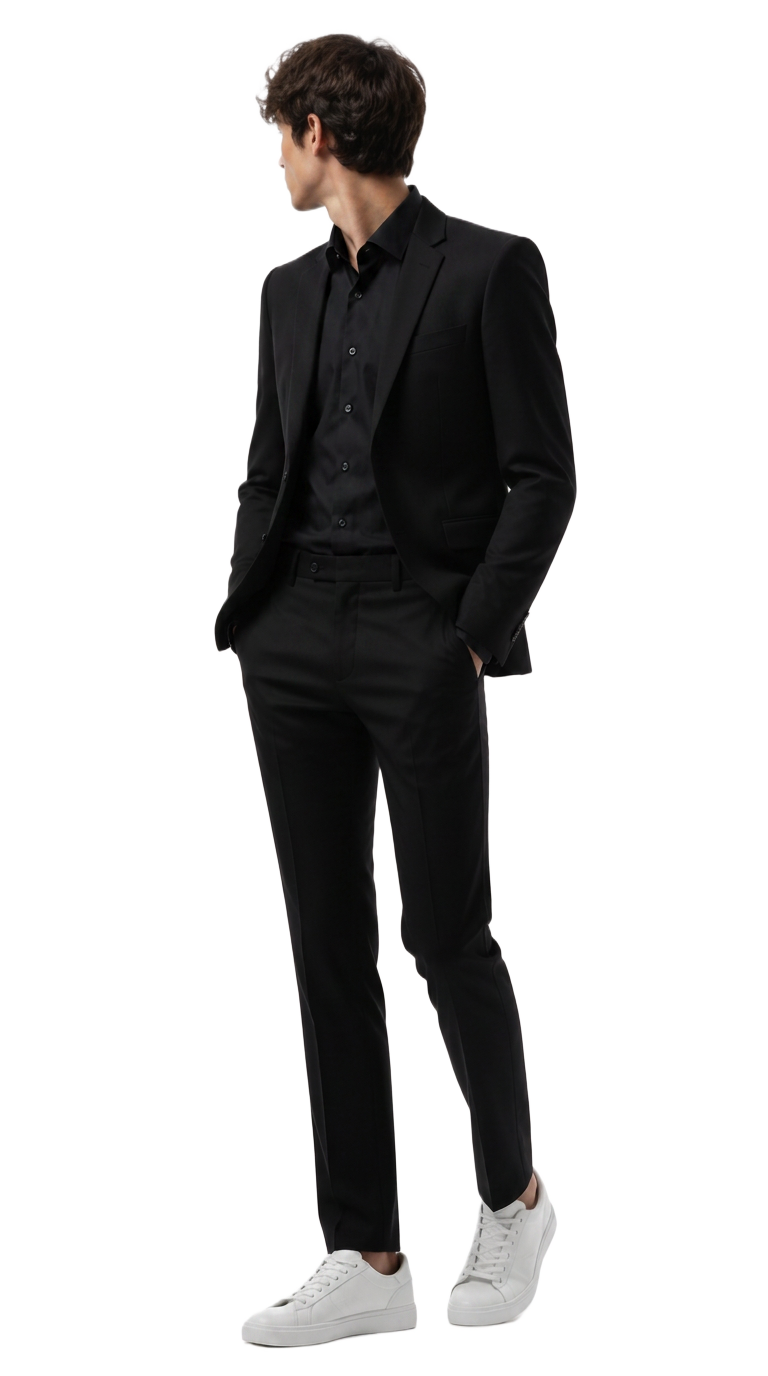 Caballero con traje negro y tenis blancos